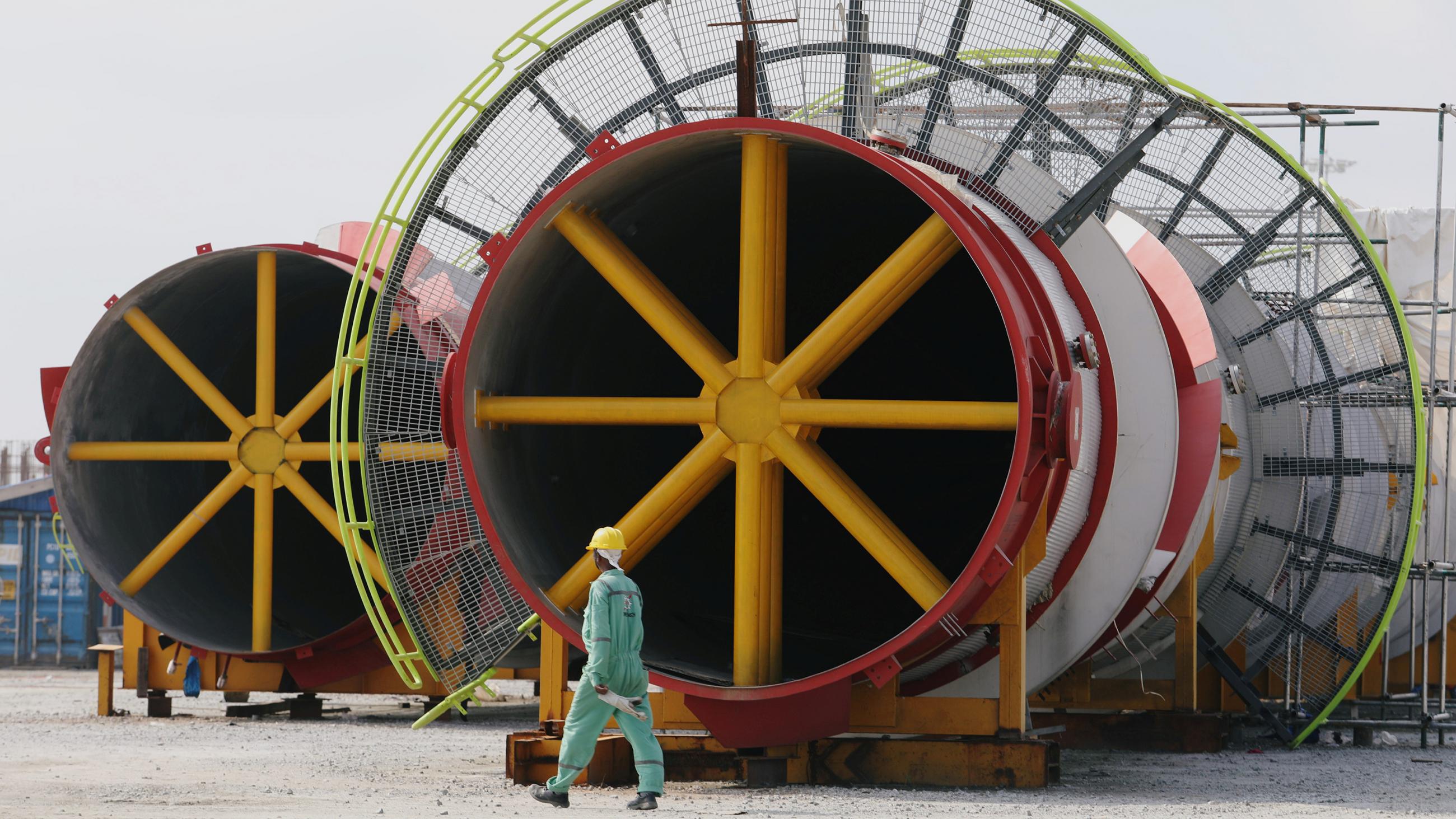 Picture shows a worker working past large metal spindles. 