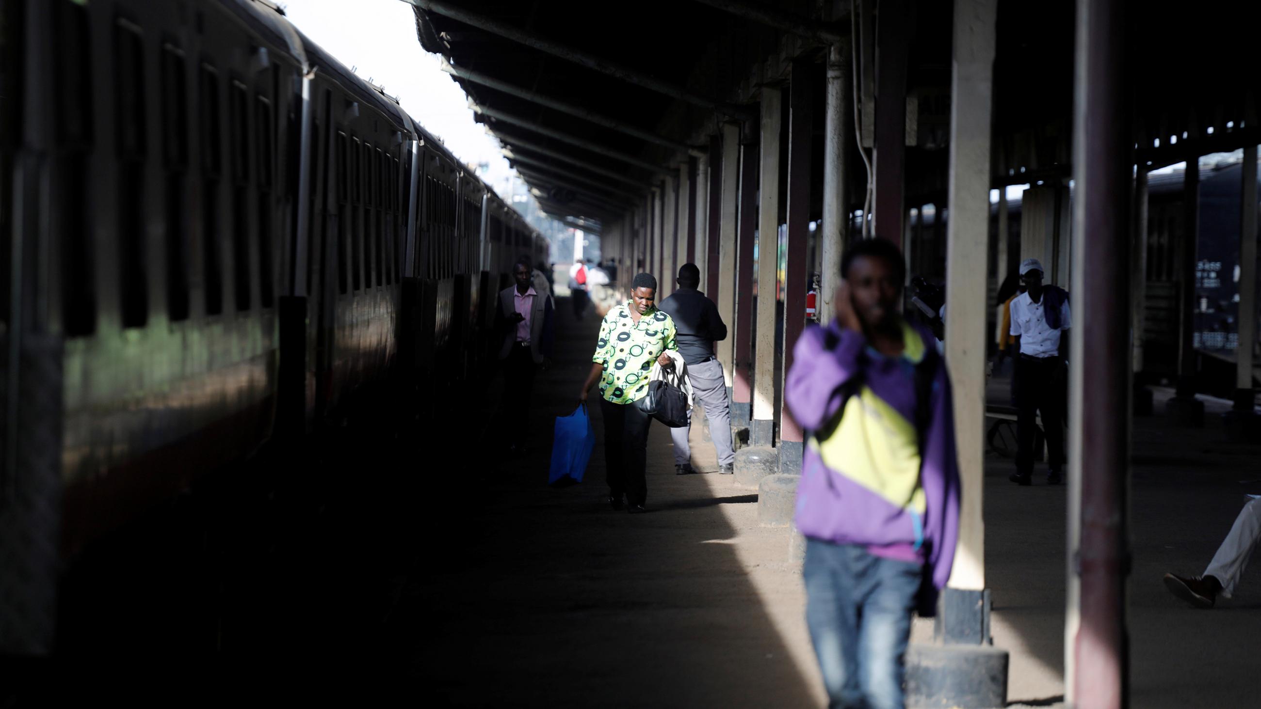 This is a striking photo of a train station with a long sliver of light striking people in the otherwise dark station.  