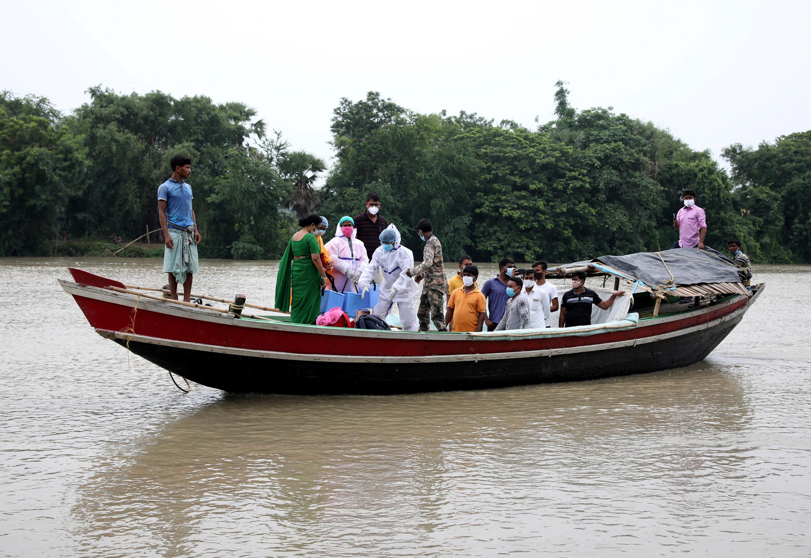 Health-care workers cross the Mundeswari River in order to vaccinate villagers during a door-to-door vaccination and testing drive at Uttar Batora Island in Howrah District, West Bengal, India. Photo by REUTERS photographer Rupak De Chowdhuri