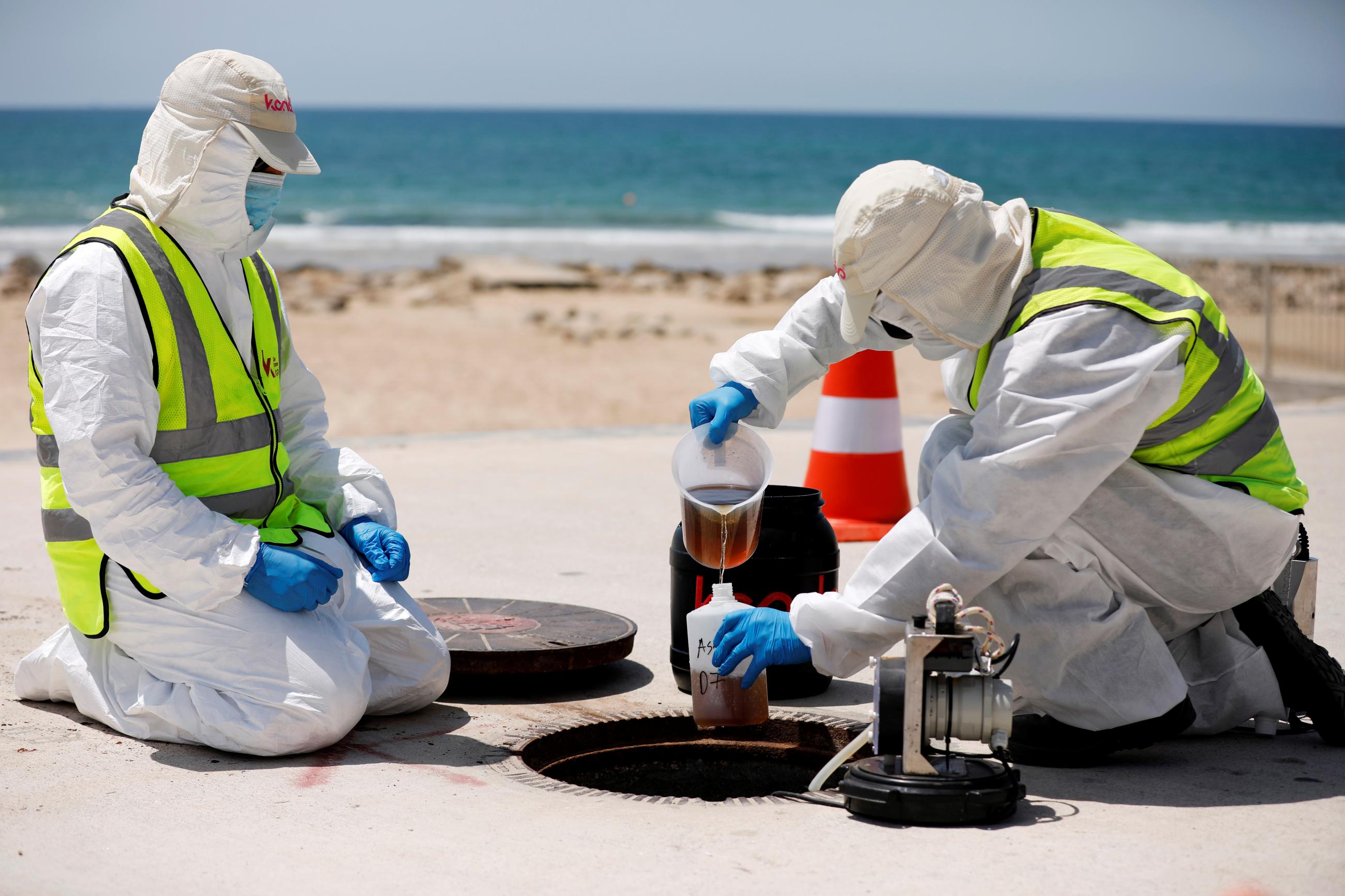 Employees of Kando, a wastewater management technology firm, where white head-to-toe protective suits and conduct sewer water surveillance which aims to identify early COVID outbreaks in Ashkelon, Israel on July 30, 2020. REUTERS/Amir Cohen