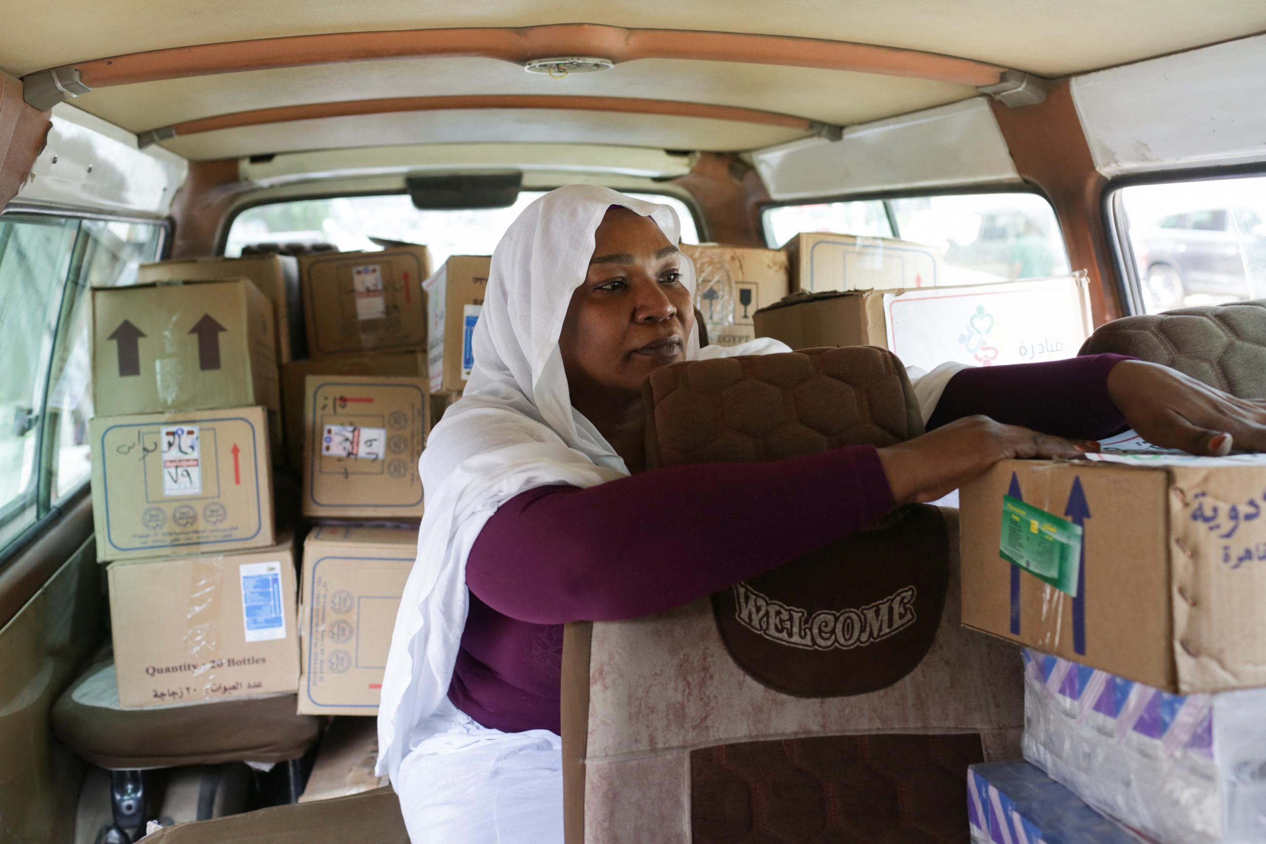 A member of a self-funded initiative organized by the principals of Sudanese schools in Egypt arranges medical boxes in a car to provide medical supplies to Sudan.