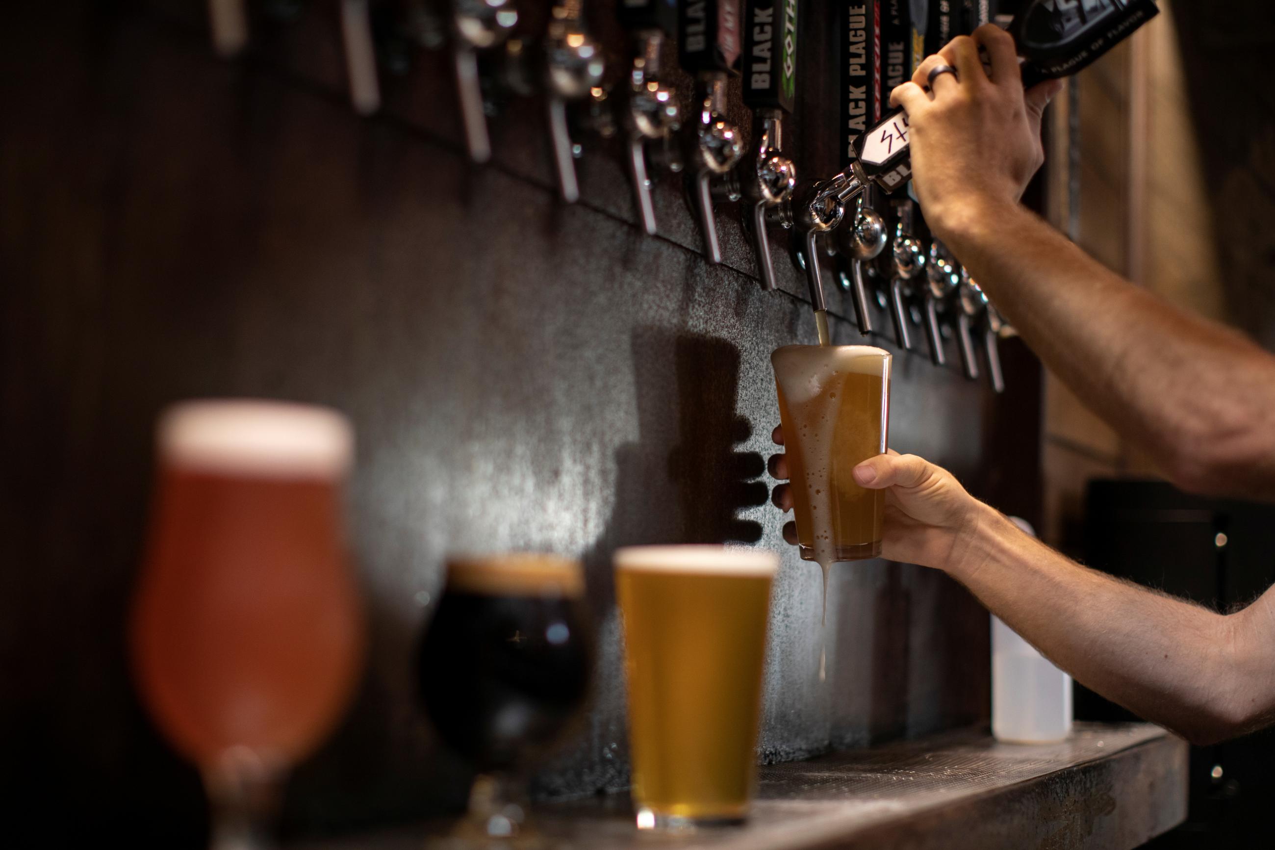 Beer is poured from a tap at Black Plague Brewery.