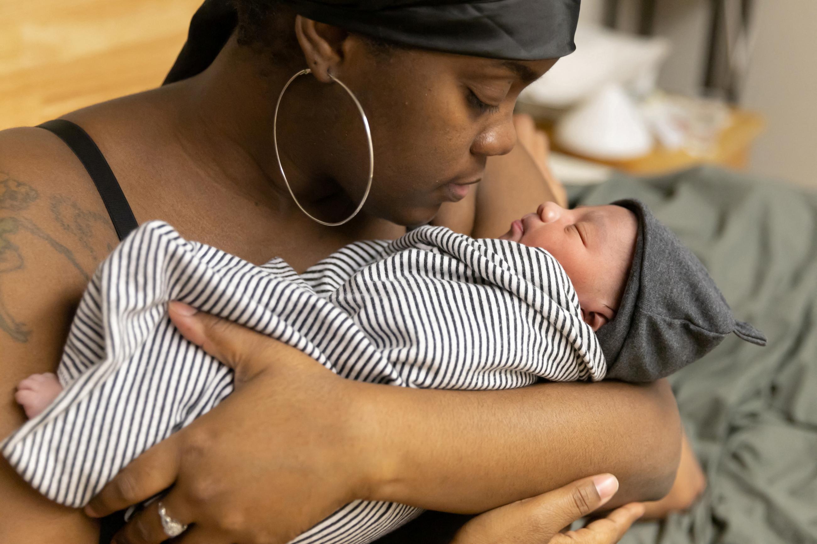 Lakayla Sobers holds her newborn son a few hours after giving birth in a birthing center.