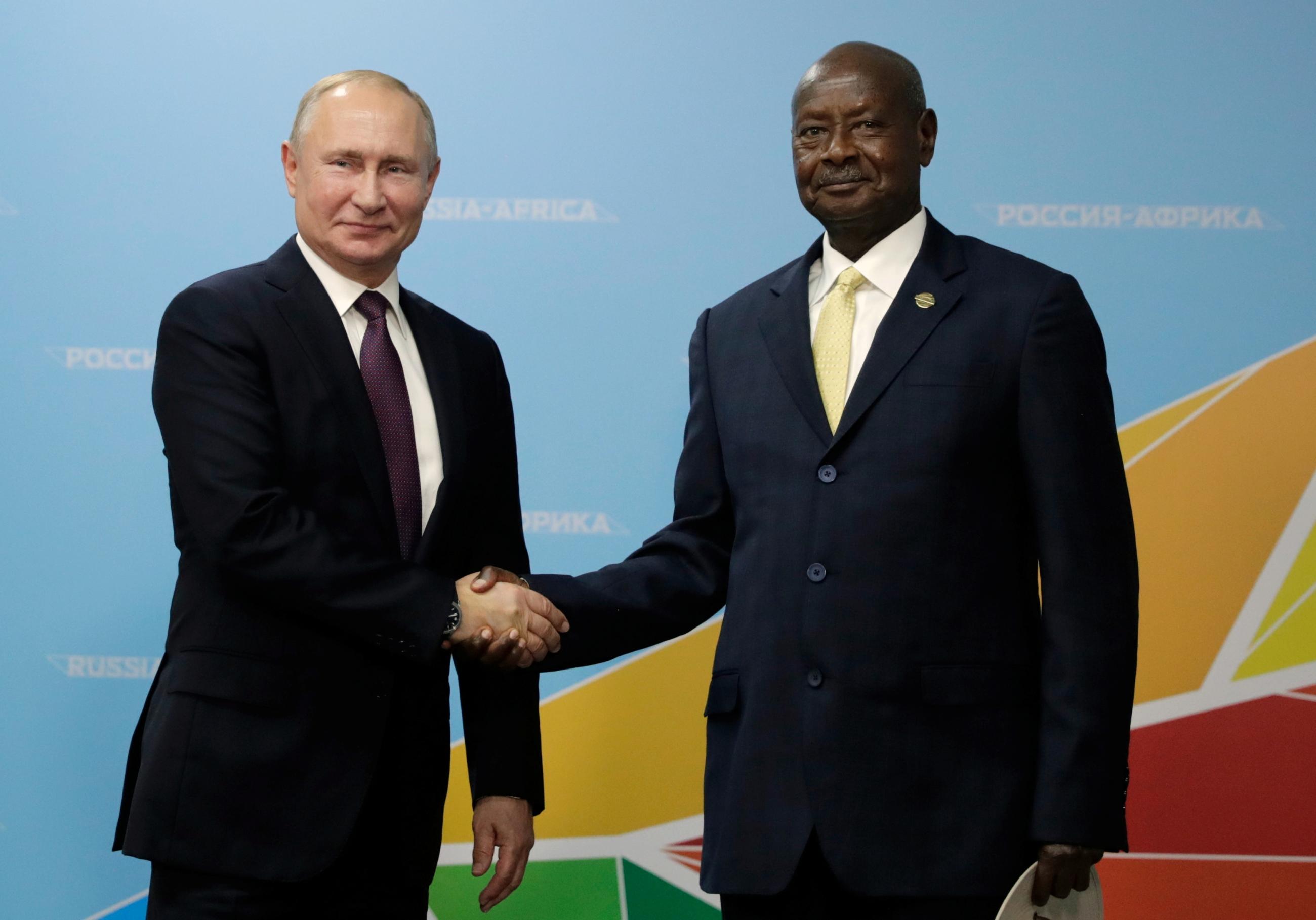 Russia's President Vladimir Putin shakes hands with Uganda's President Yoweri Museveni.