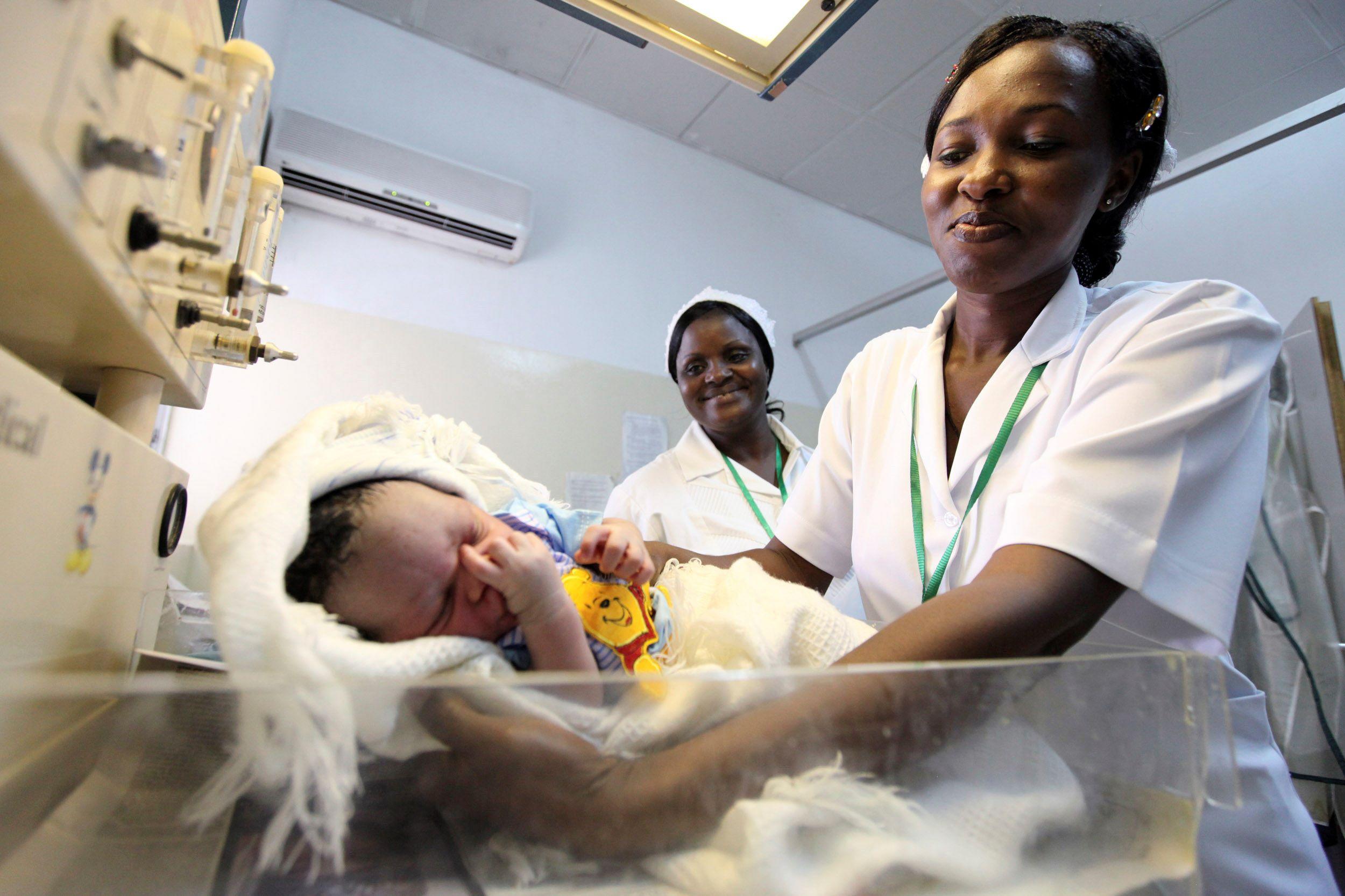 A nurse weighs a baby, at the Maitama district hospital, in Abuja, Nigeria, on May 22, 2011.