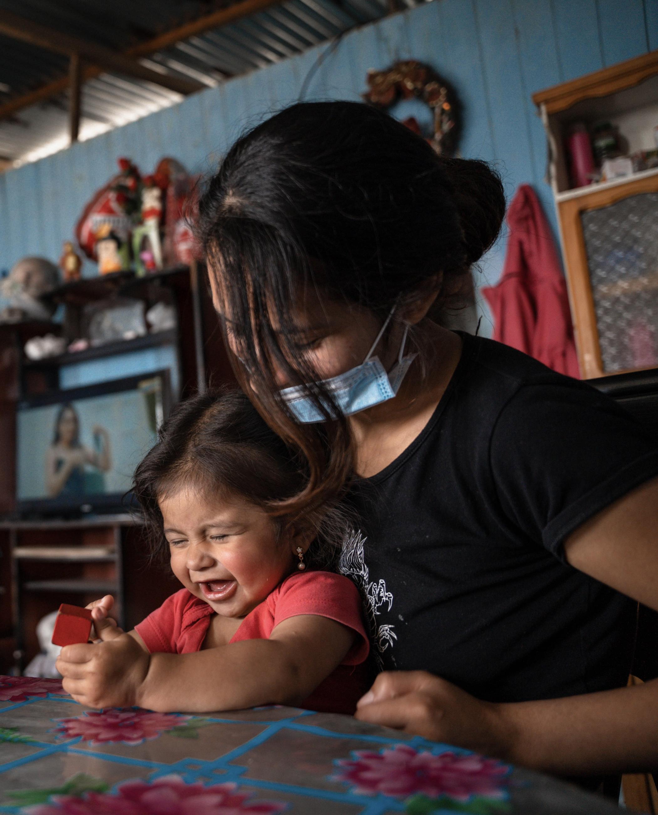 A young girl completes a task for her development evaluation in Lima, Peru, on August 24, 2022.