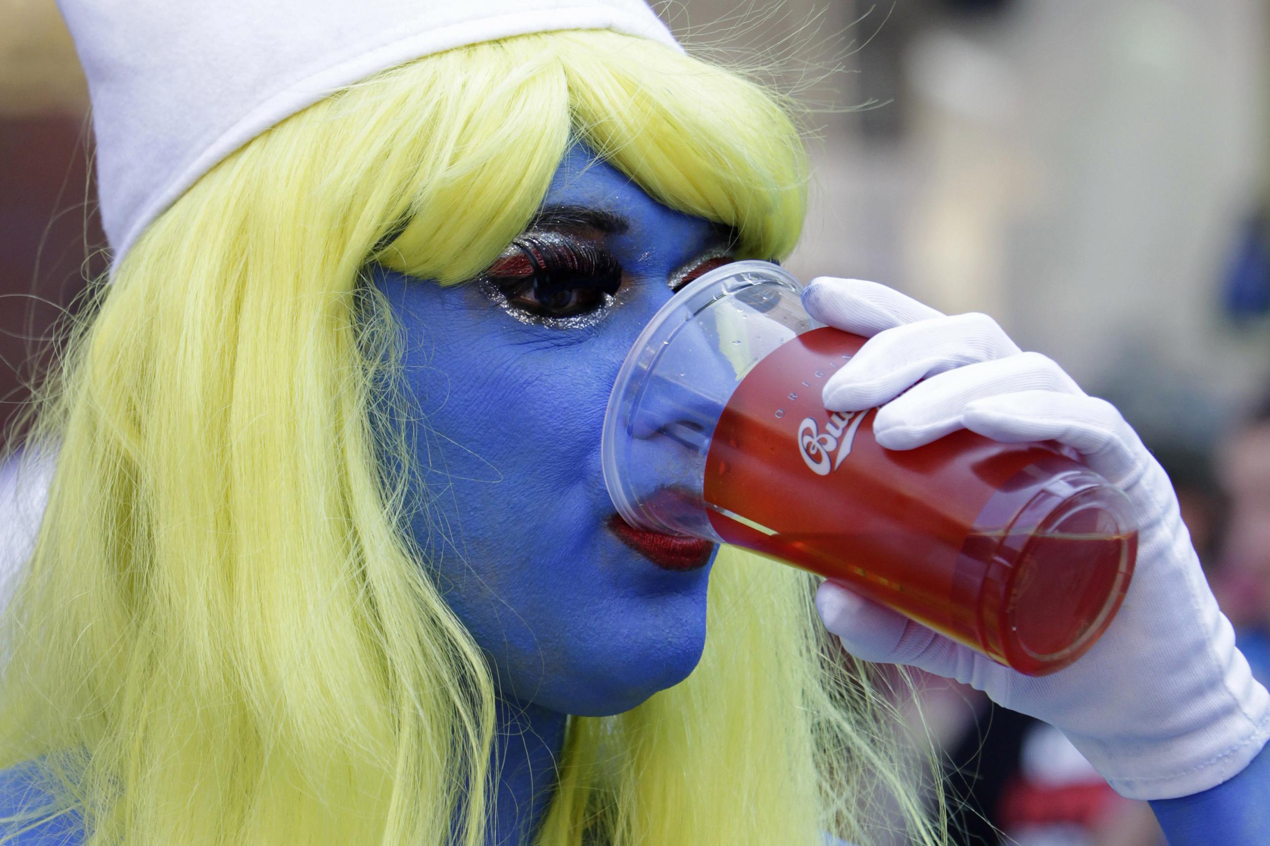 A participant drinks beer during a Pride Parade.