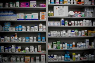 Bottles of medications line the shelves of a pharmacy.