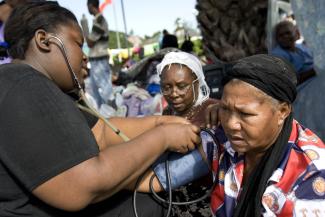 A nurse takes a woman's blood pressure.