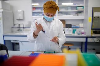 A researcher manipulates proteins in a laboratory as part of a project to develop a COVID nasal spray vaccine.