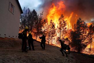 A group of U.S. Forest Service firefighters monitor a back fire while battling to save homes at the Camp Fire in Paradise, California, on November 8, 2018.