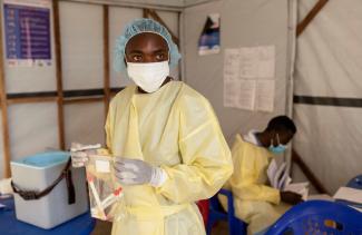 A laboratory nurse carries samples taken from a child with a suspected case of mpox.