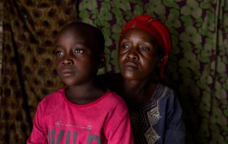 Fideline Kiza Kasao and her son Kito Balume both who recovered from mpox, pose for a photograph inside their shelter.