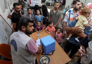 Palestinian children, accompanied by parents, wait to be vaccinated against polio.