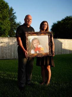 Kelly and Ryan Breaux stand holding a portrait of their deceased daughter Emma Breaux, at their home in Breaux Bridge, Louisiana, on June 16, 2016. The couple lost twins, Emma and Talon, to superbugs.